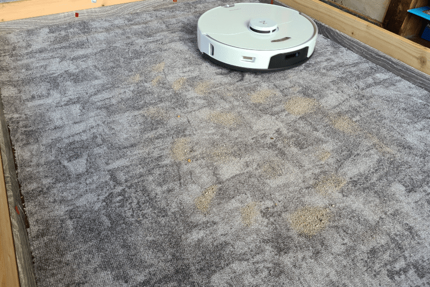Roborock S7 Pro Ultra vacuum robot cleans sand on a low pile carpet.